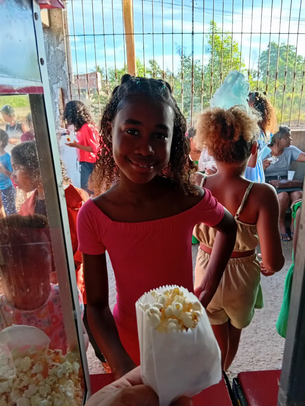 Crianças com algodão doce e pipoca na mão durante a festa
